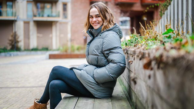 Galina-sitter-på-en-benk-utenfor-hjemmet-sitt